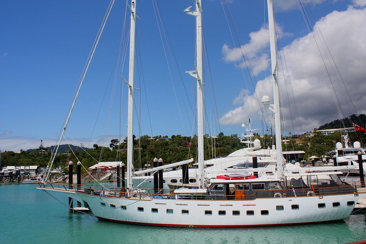 Sailing catamaran cruising through turquoise waters between Whitsunday Islands