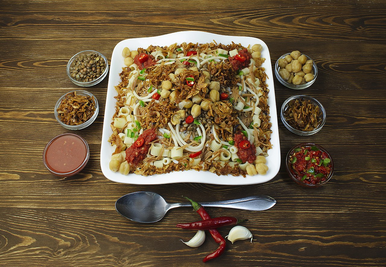 Egyptian koshari dish with rice lentils macaroni and tomato sauce in traditional serving bowl