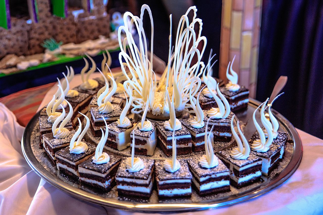 Small expedition cruise ship anchored in Antarctic bay surrounded by icebergs and mountains