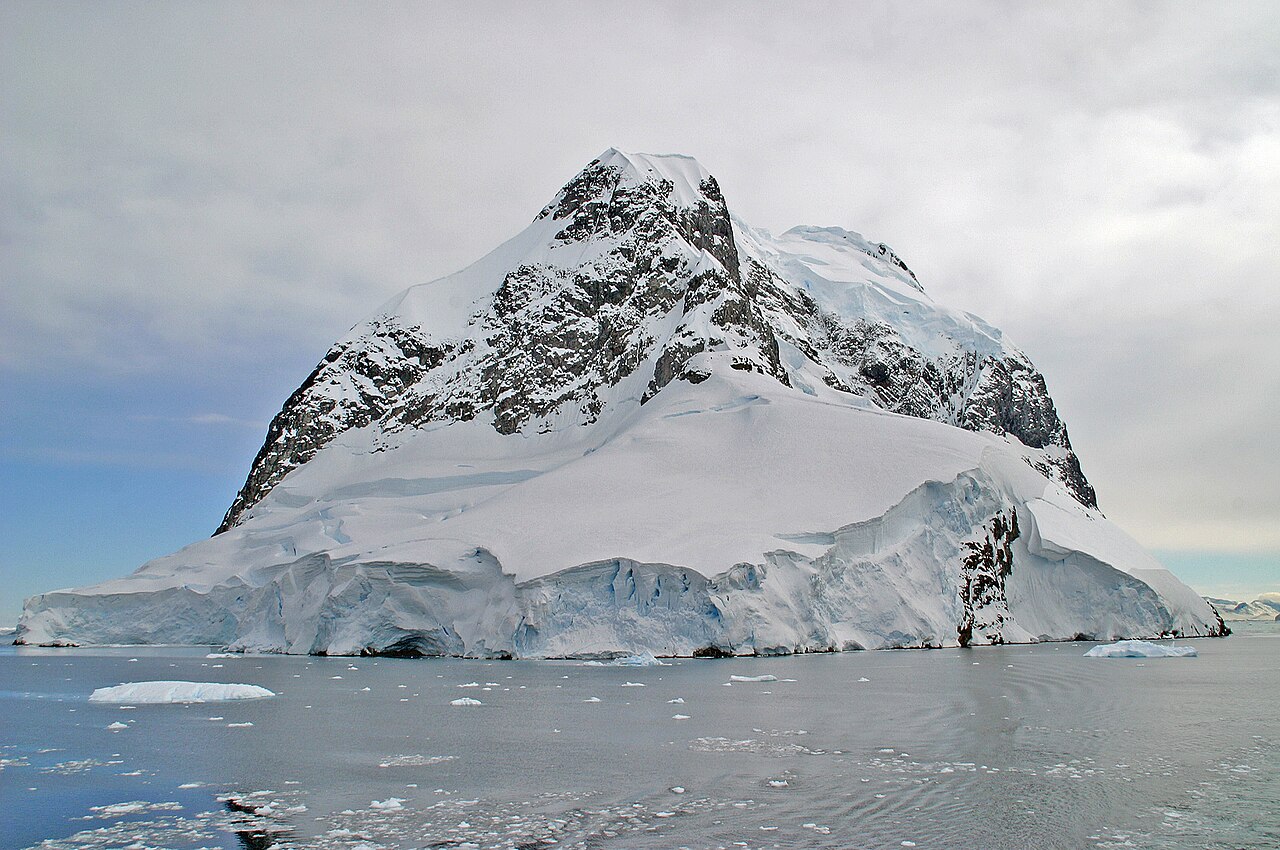 Ship passing through narrow Lemaire Channel between towering ice-covered cliffs