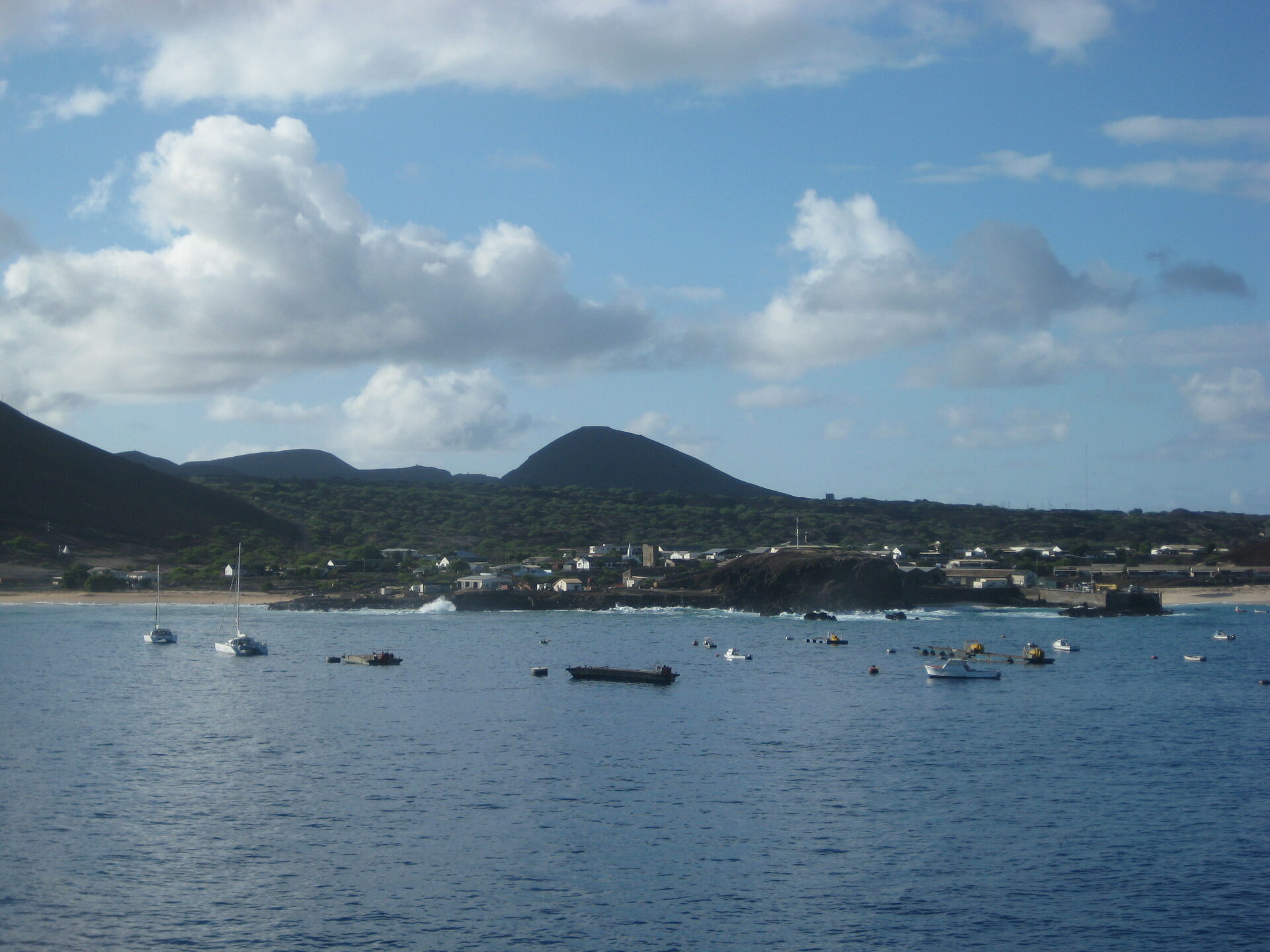 Small Georgetown settlement with colorful buildings beneath volcanic peaks