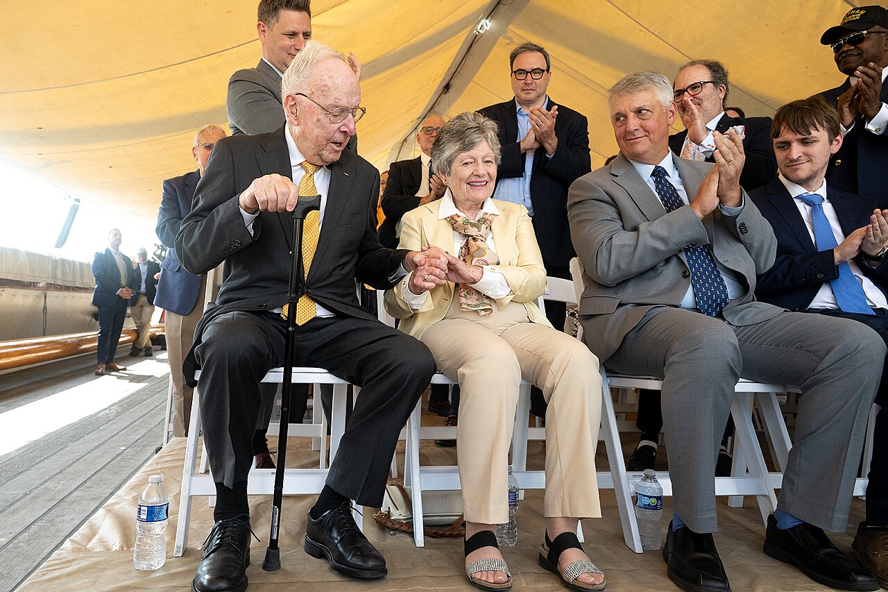 USS Constellation tall ship with three masts docked at Inner Harbor against city skyline