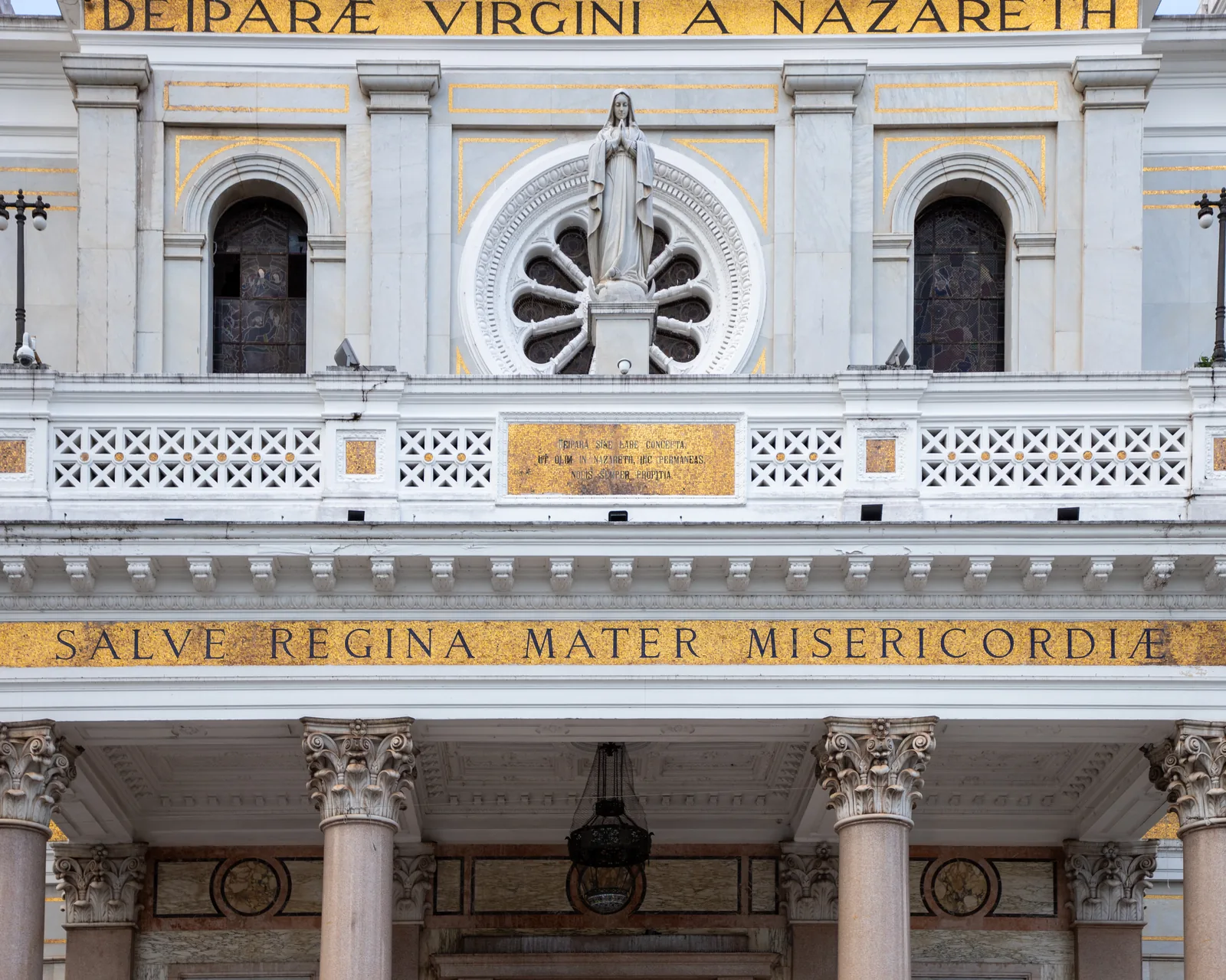 The marble front of the Basílica de Nossa Senhora de Nazaré at Belém, with its rose window, statue of the Virgin and gold-mosaic inscriptions