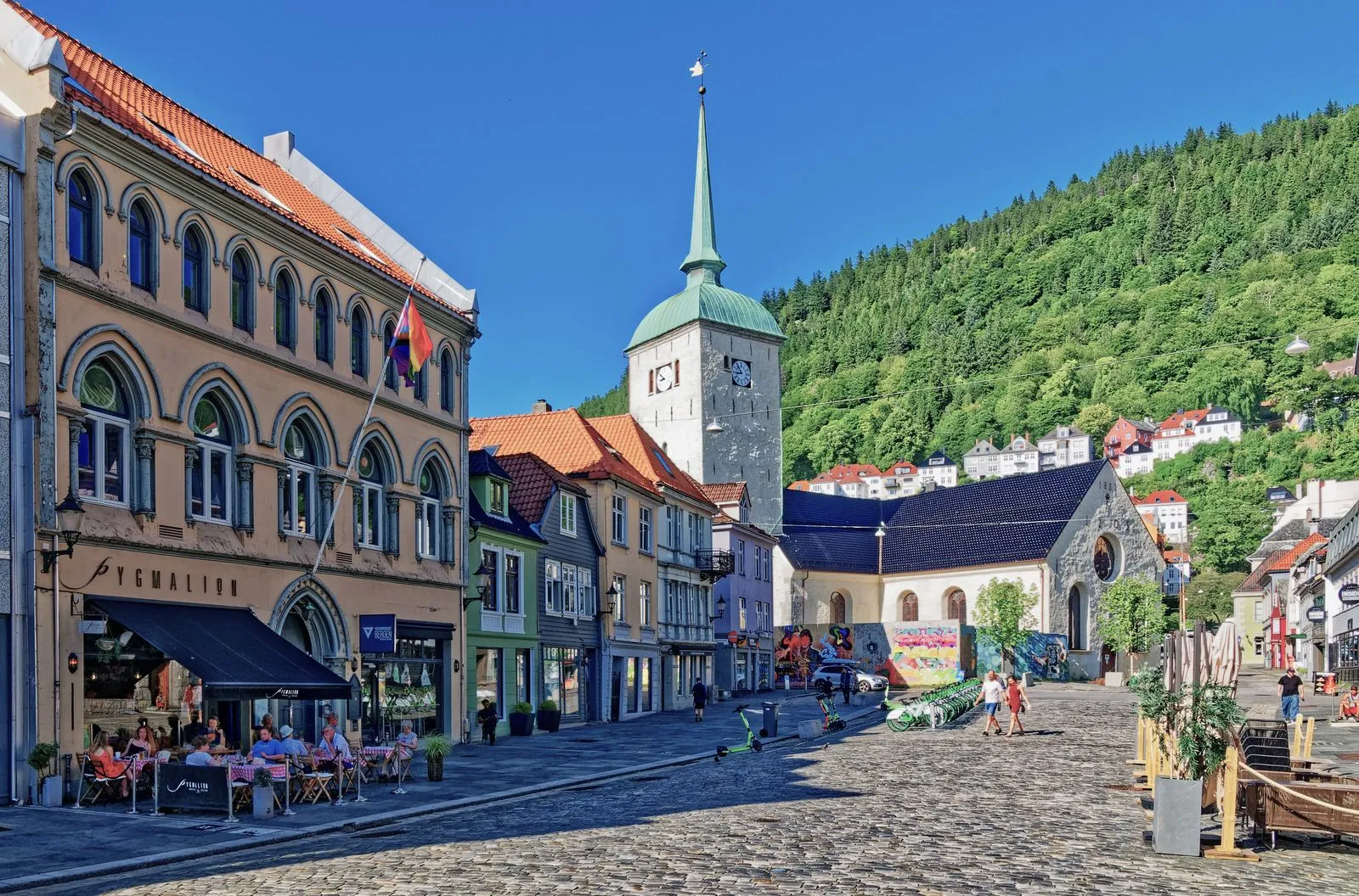 Colorful wooden Bryggen wharf buildings reflected in Bergen harbor with mountains rising behind