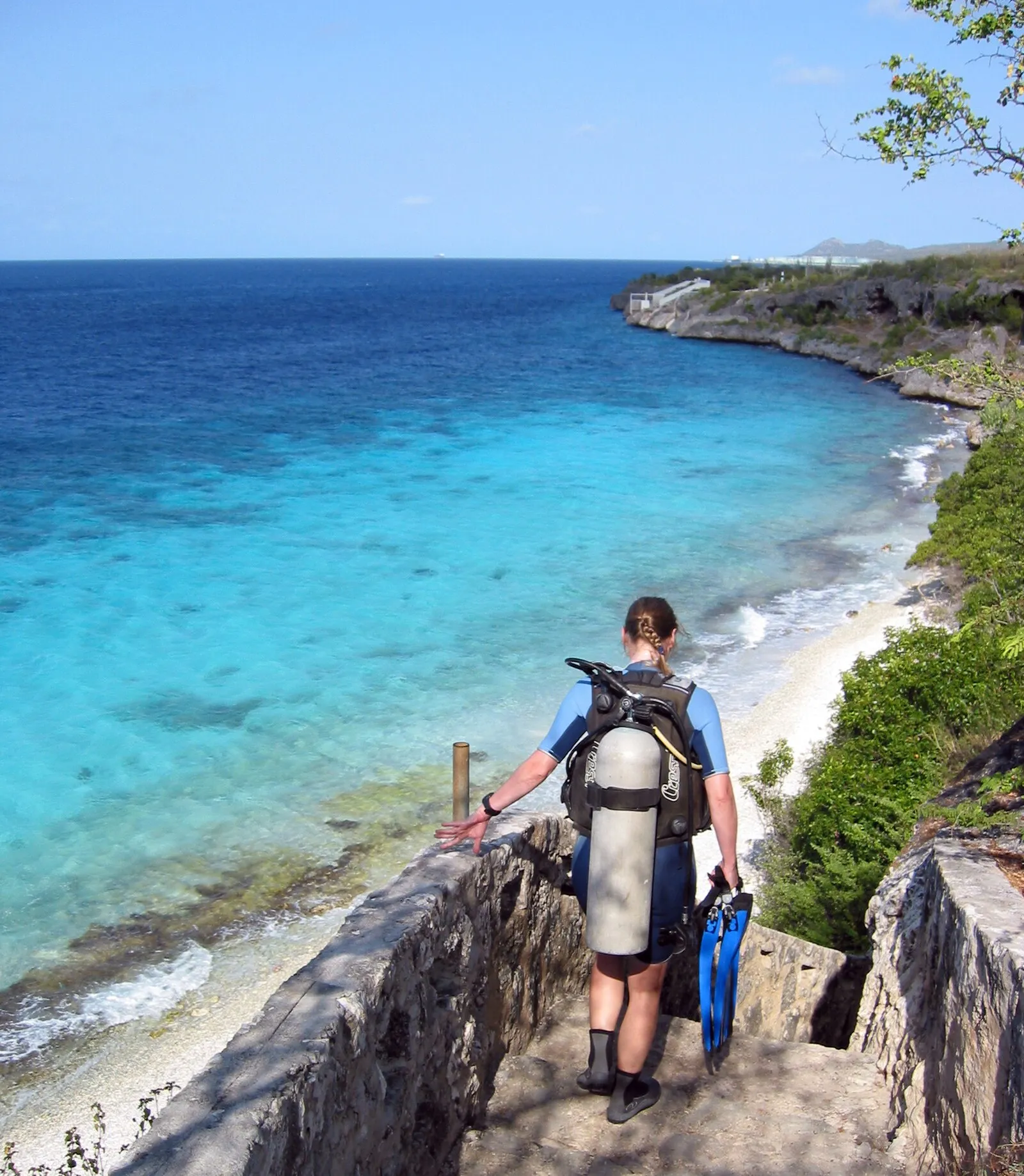 Scuba diver descending limestone steps to shore dive at Bonaire's reef