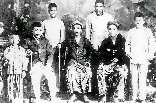 Historical black and white photograph of Bruneian men and boys in traditional dress, early 20th century