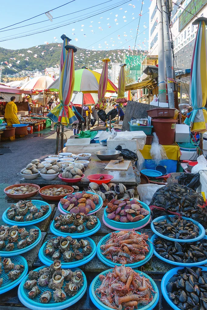 Busan skyline with mountains meeting the sea and Haeundae Beach in the foreground