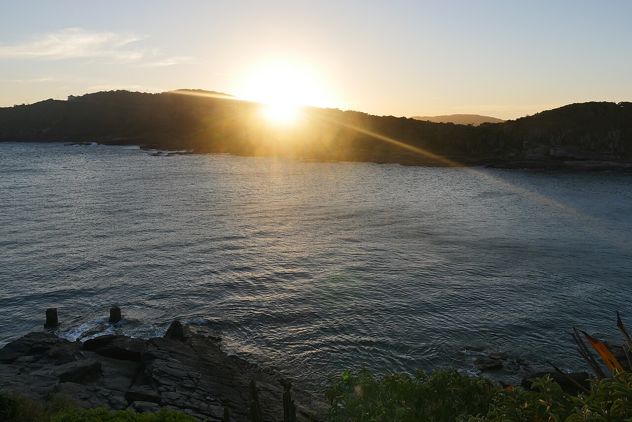 Sunset over a Búzios cove with rocky coastline