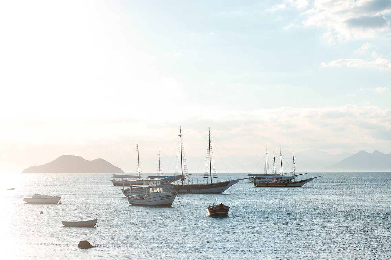 Schooners and sailing boats anchored in calm Búzios bay with mountains behind