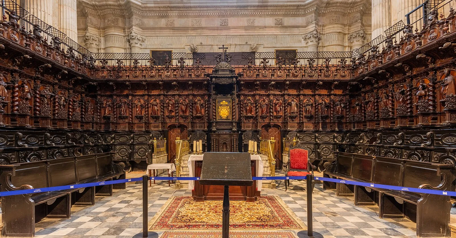 Narrow cobblestone street in Barrio del Pópulo with whitewashed buildings and laundry on balconies