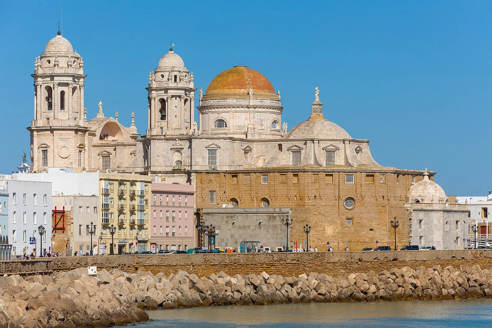 Palm-lined waterfront promenade of Cádiz with Atlantic Ocean and fishing boats
