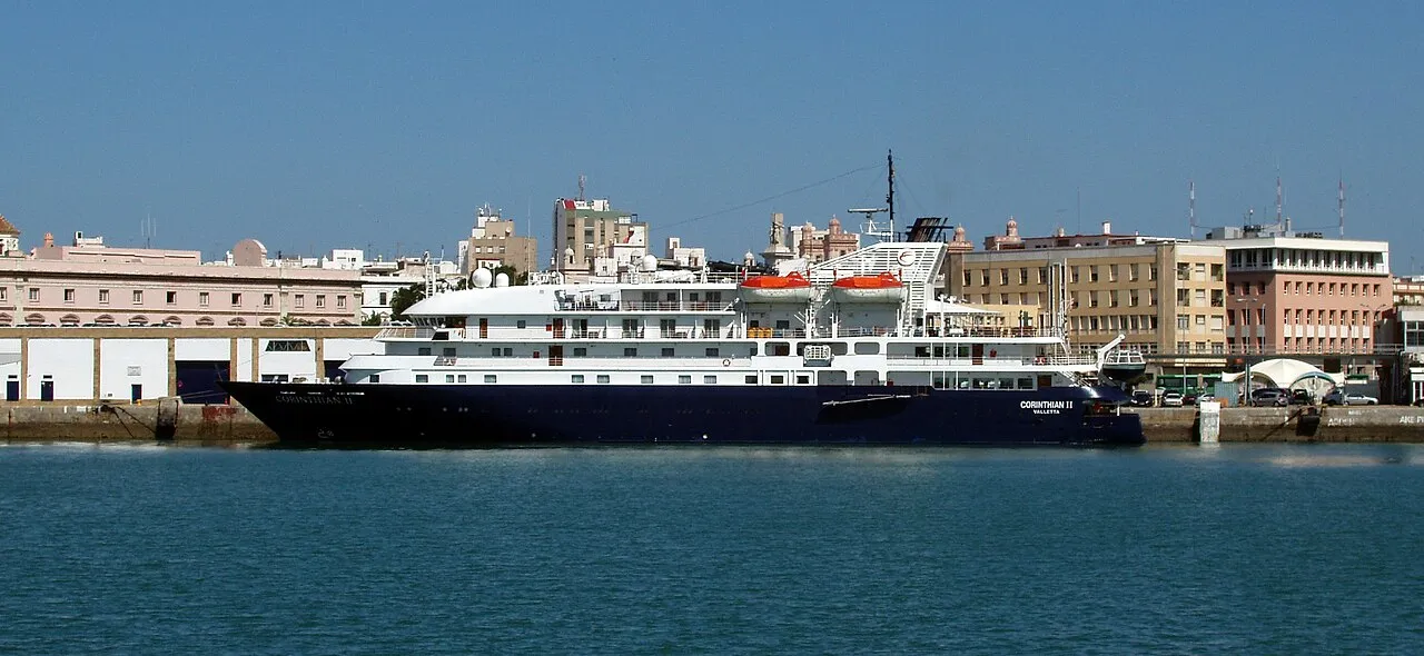 Golden cathedral dome and white buildings of Cádiz old town against blue Atlantic Ocean and sky