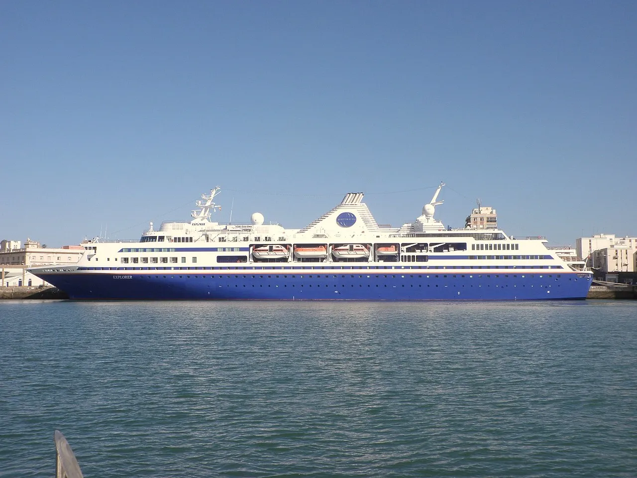 Golden dome of Cádiz Cathedral rising above white buildings with Atlantic Ocean in background