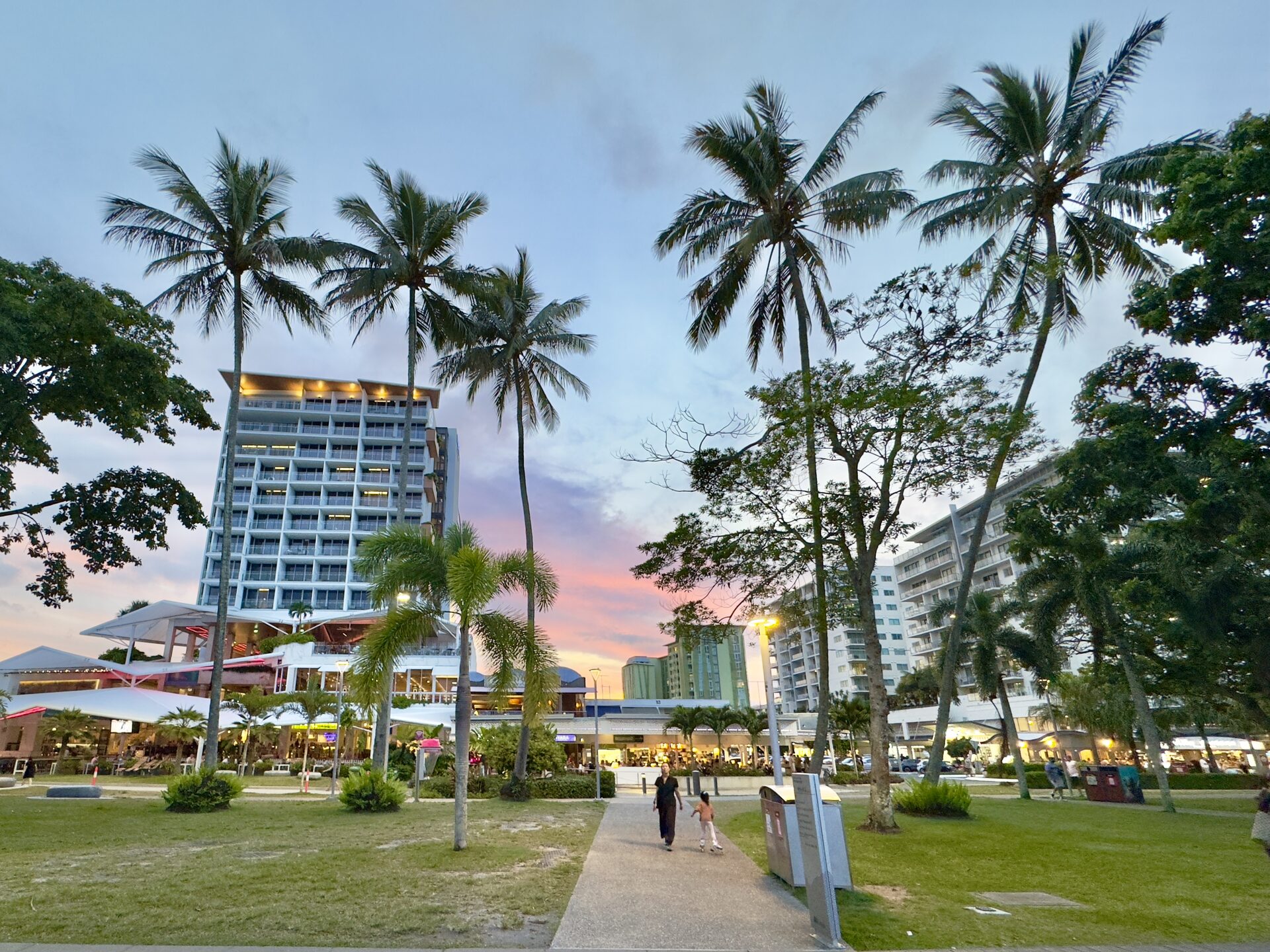 Cairns Esplanade boardwalk with palm trees, lagoon swimming area, and Trinity Inlet views
