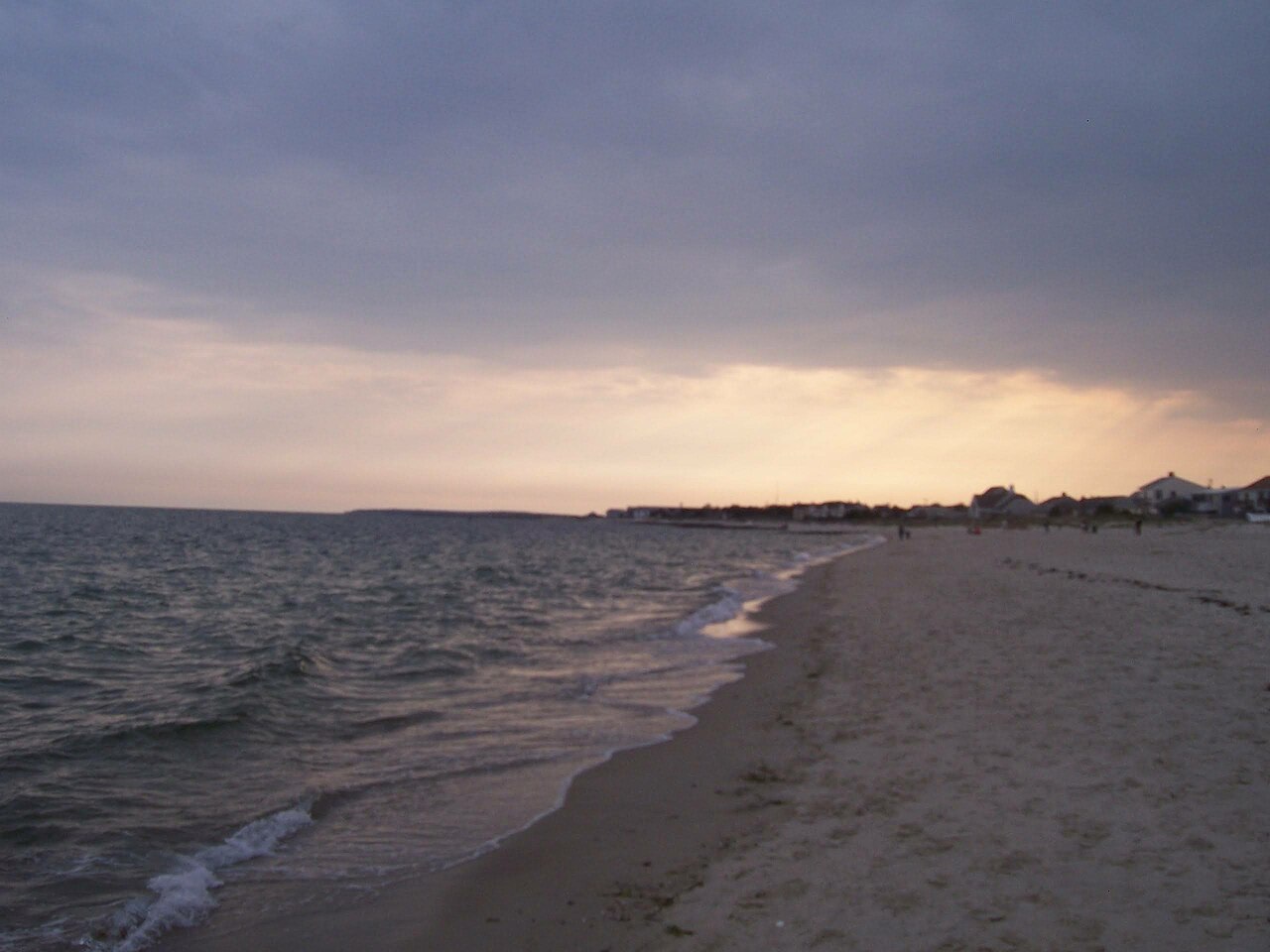 Cape Cod beach at dusk with distant houses