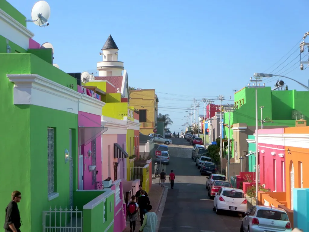 Colorful houses lining Chiappini Street in the Bo-Kaap neighborhood with mosque minaret visible
