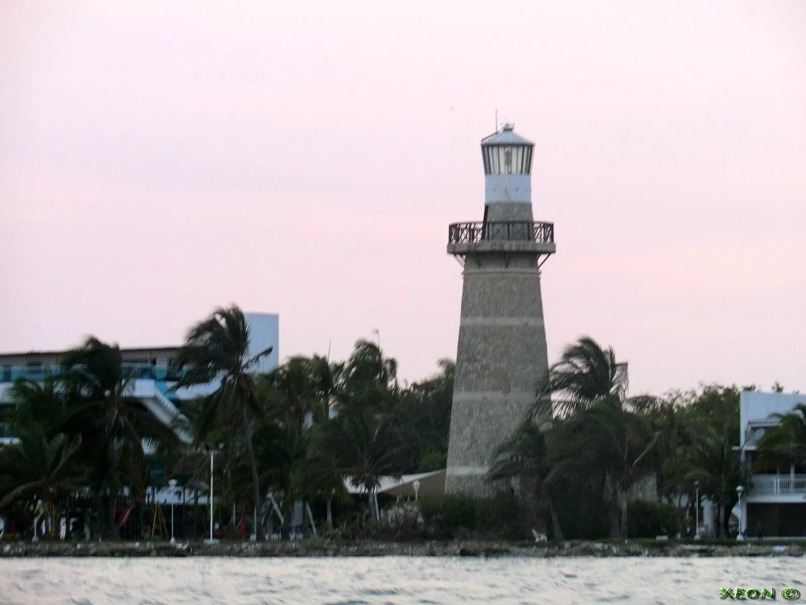 Lighthouse with palm trees at sunset on the Cartagena waterfront