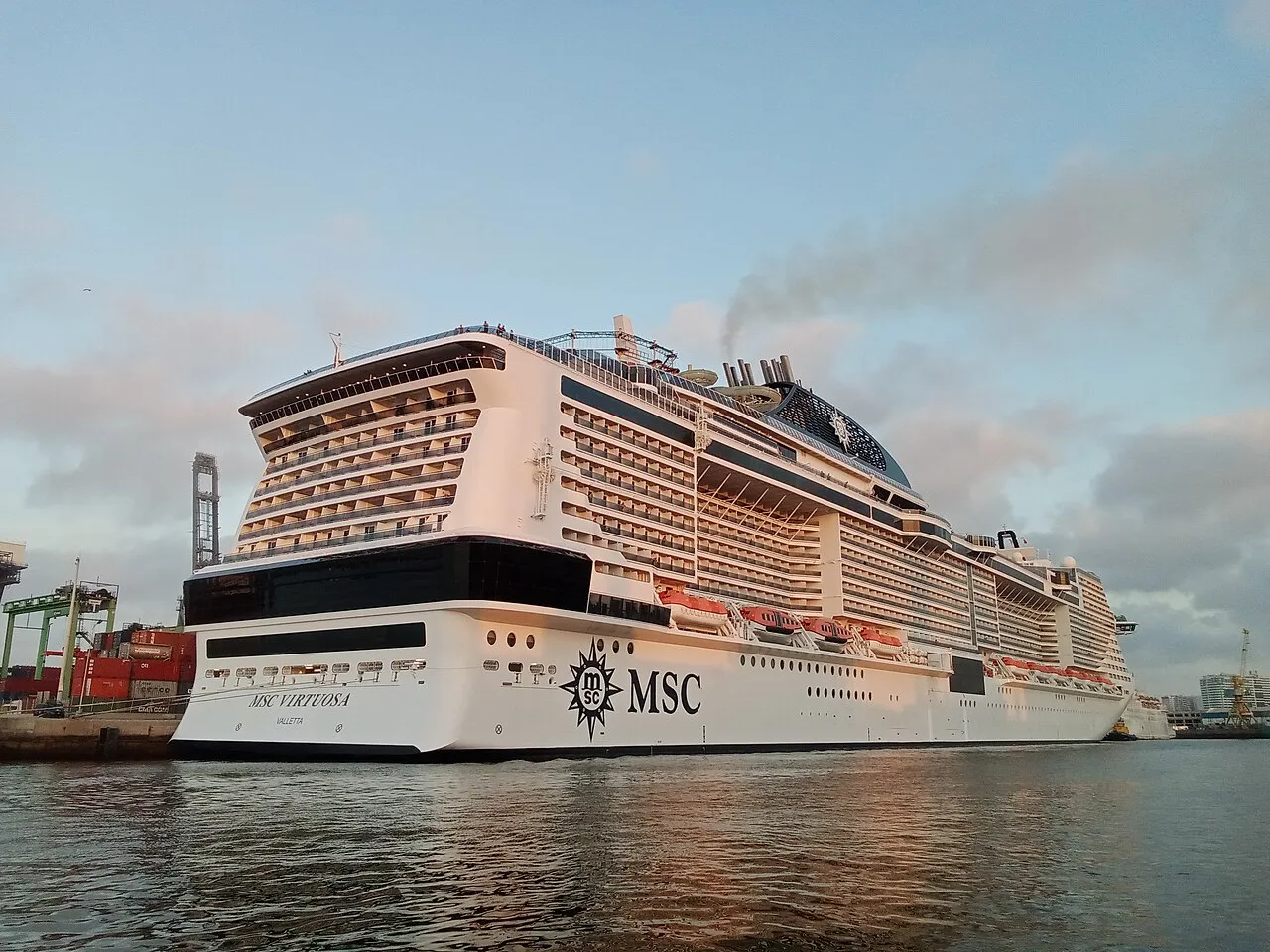 Hassan II Mosque minaret rising against blue sky with Atlantic Ocean waves crashing below