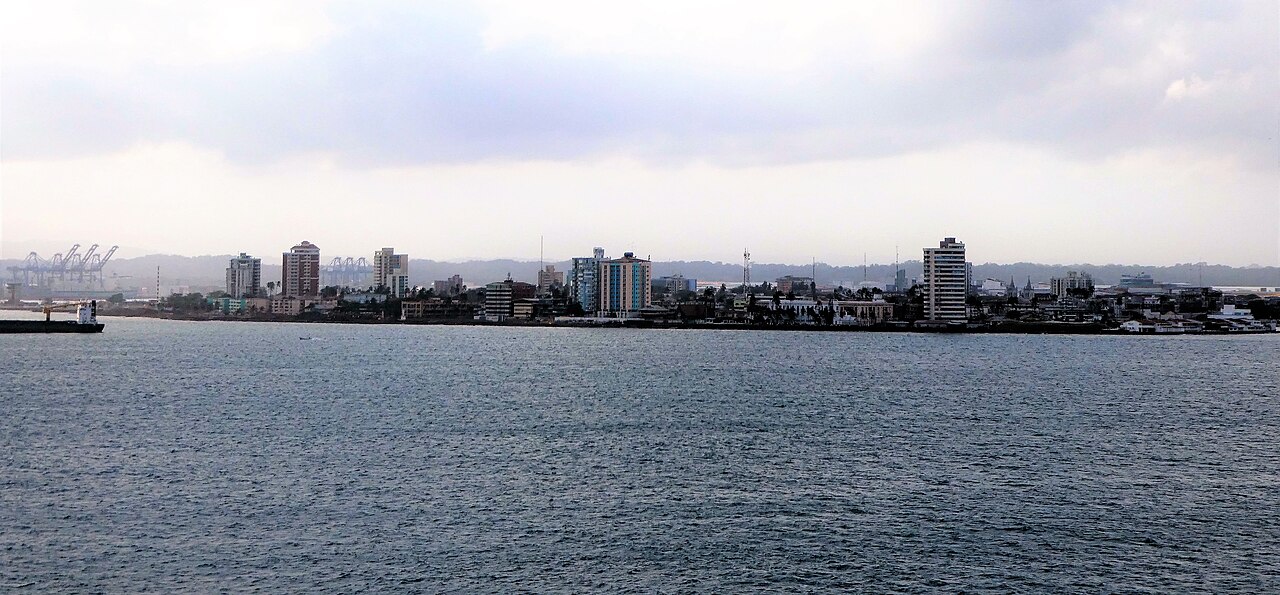 Colón city skyline seen from the water with container port cranes and high-rise buildings