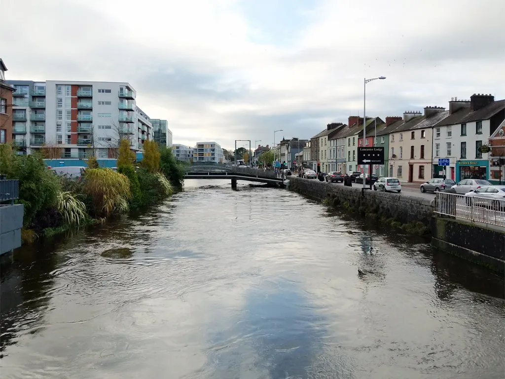 River Lee flowing through Cork city centre with colourful row houses and Lancaster Lodge on the quay