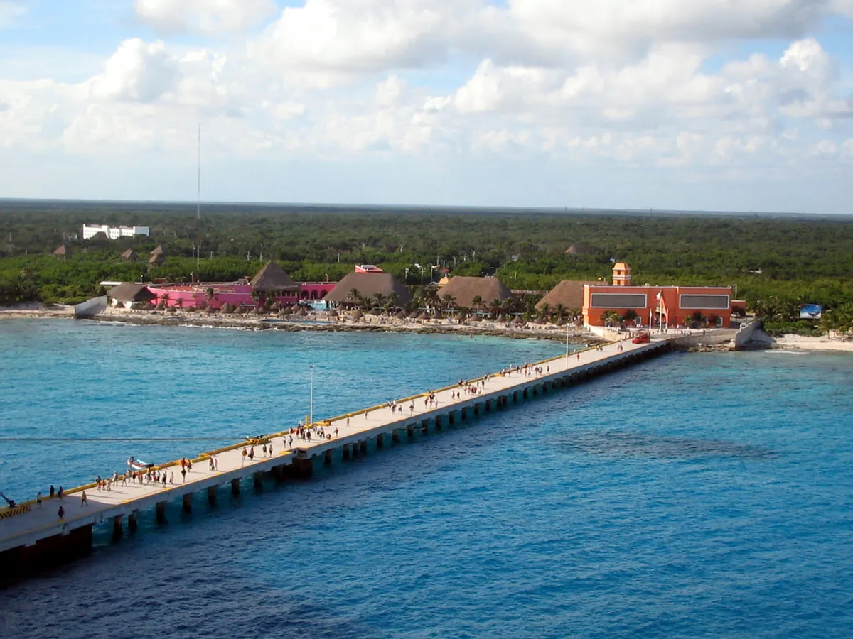 Aerial view of Costa Maya cruise pier from ship showing colorful port buildings and Yucatán jungle