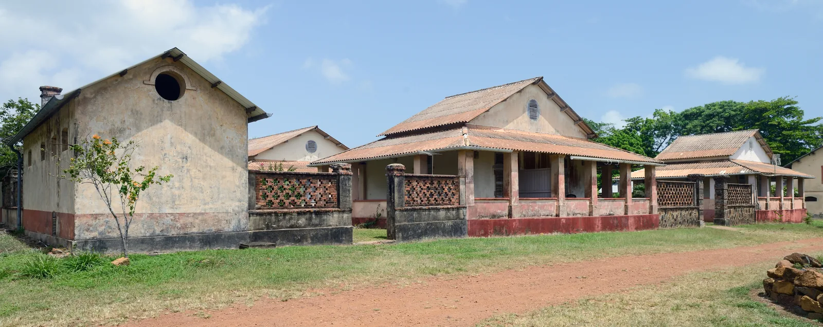 The former houses of the prison warders on Île Royale, low colonial buildings among palms
