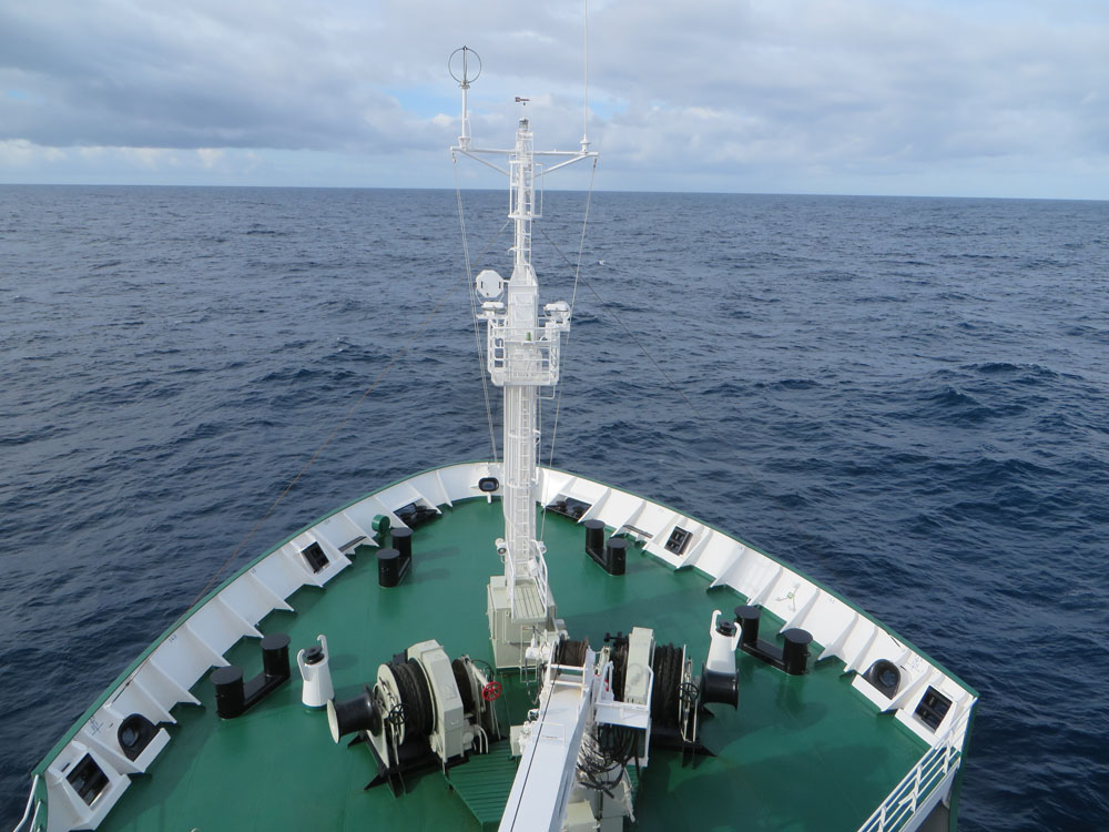 View from an expedition ship's bow crossing the open Southern Ocean under overcast skies