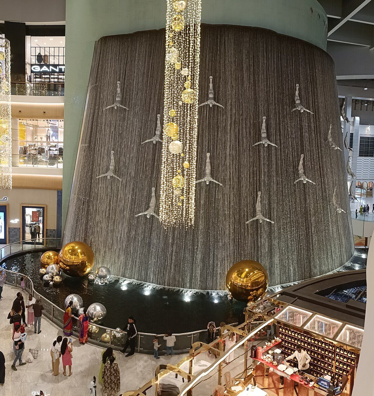 The Waterfall sculpture inside Dubai Mall with silver human figures diving alongside cascading water
