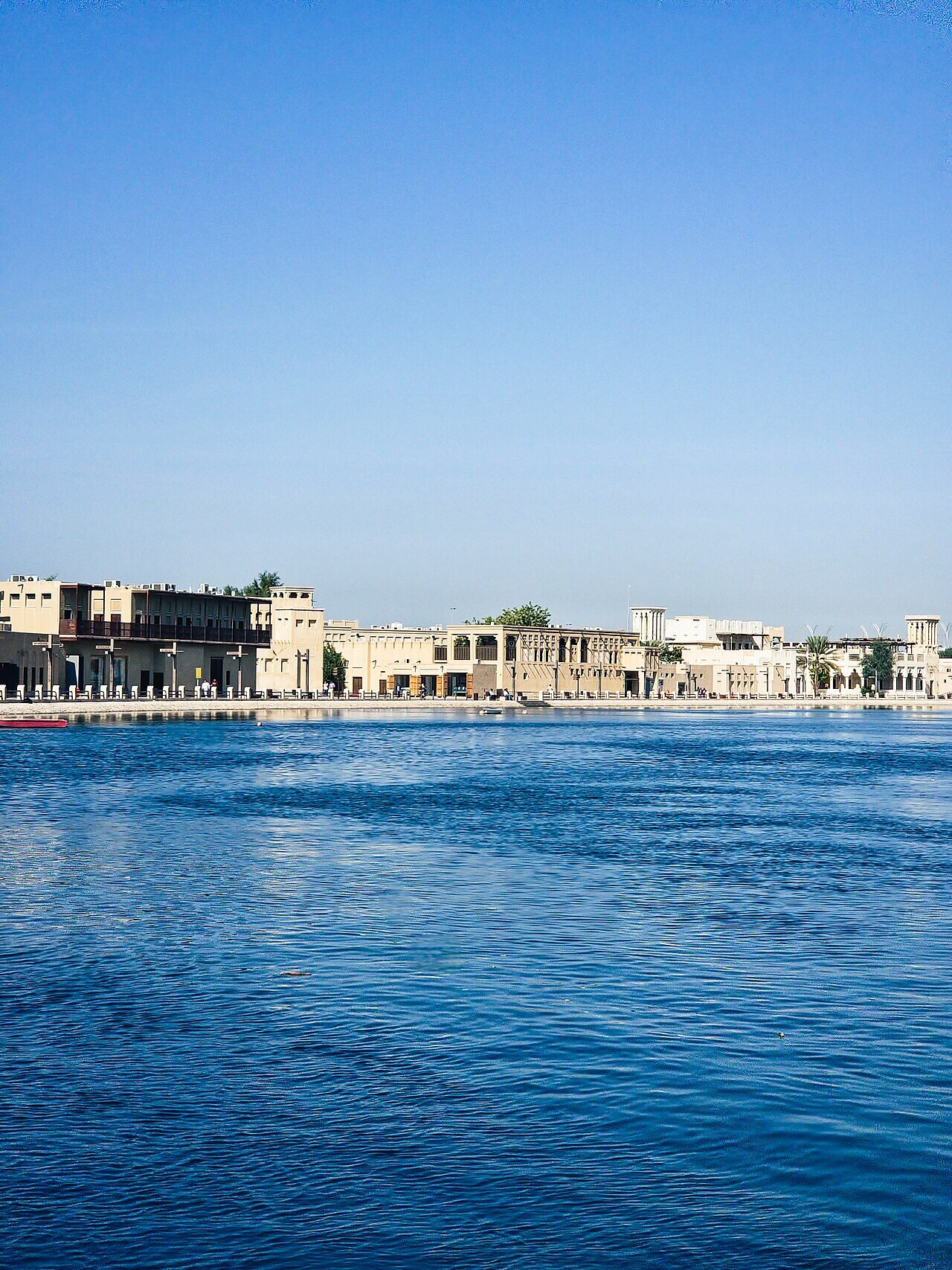 Traditional low-rise buildings along Dubai Creek waterfront in the Al Fahidi district