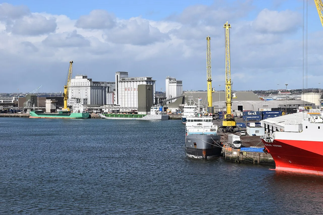 Dublin Port with grain silos, yellow cranes, and cargo vessels at berth
