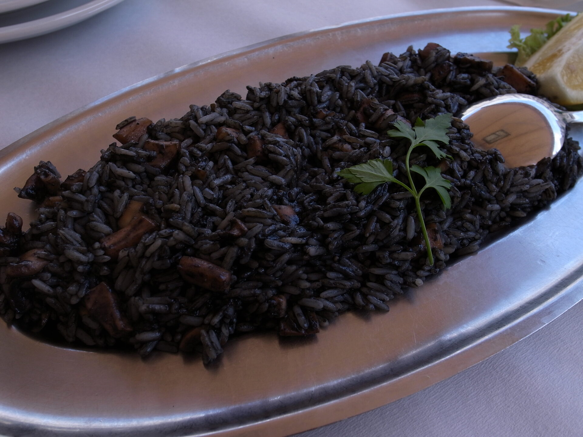 Croatian black risotto (crni rižot) with squid ink served on a silver platter