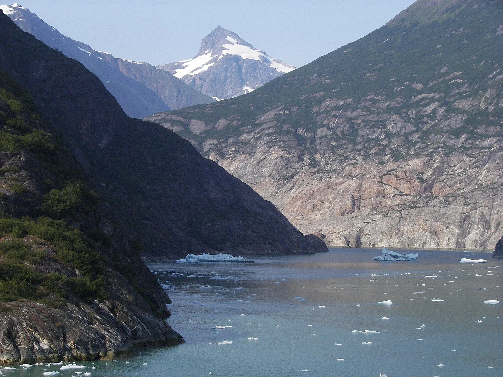 Dawes Glacier massive blue ice face rising 600 feet with calving ice chunks