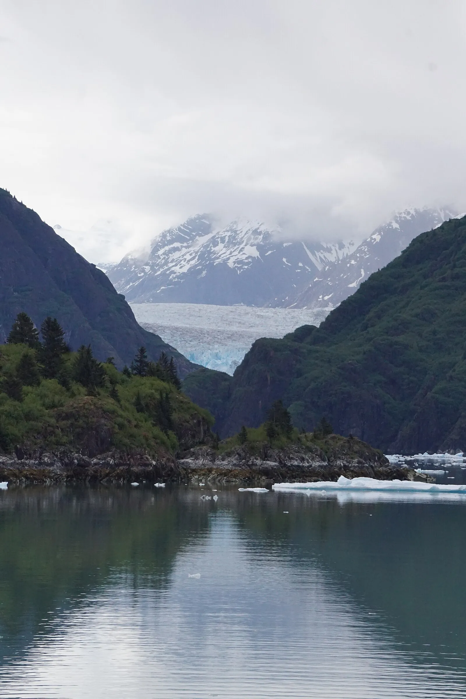 Waterfall cascading down granite cliff into fjord