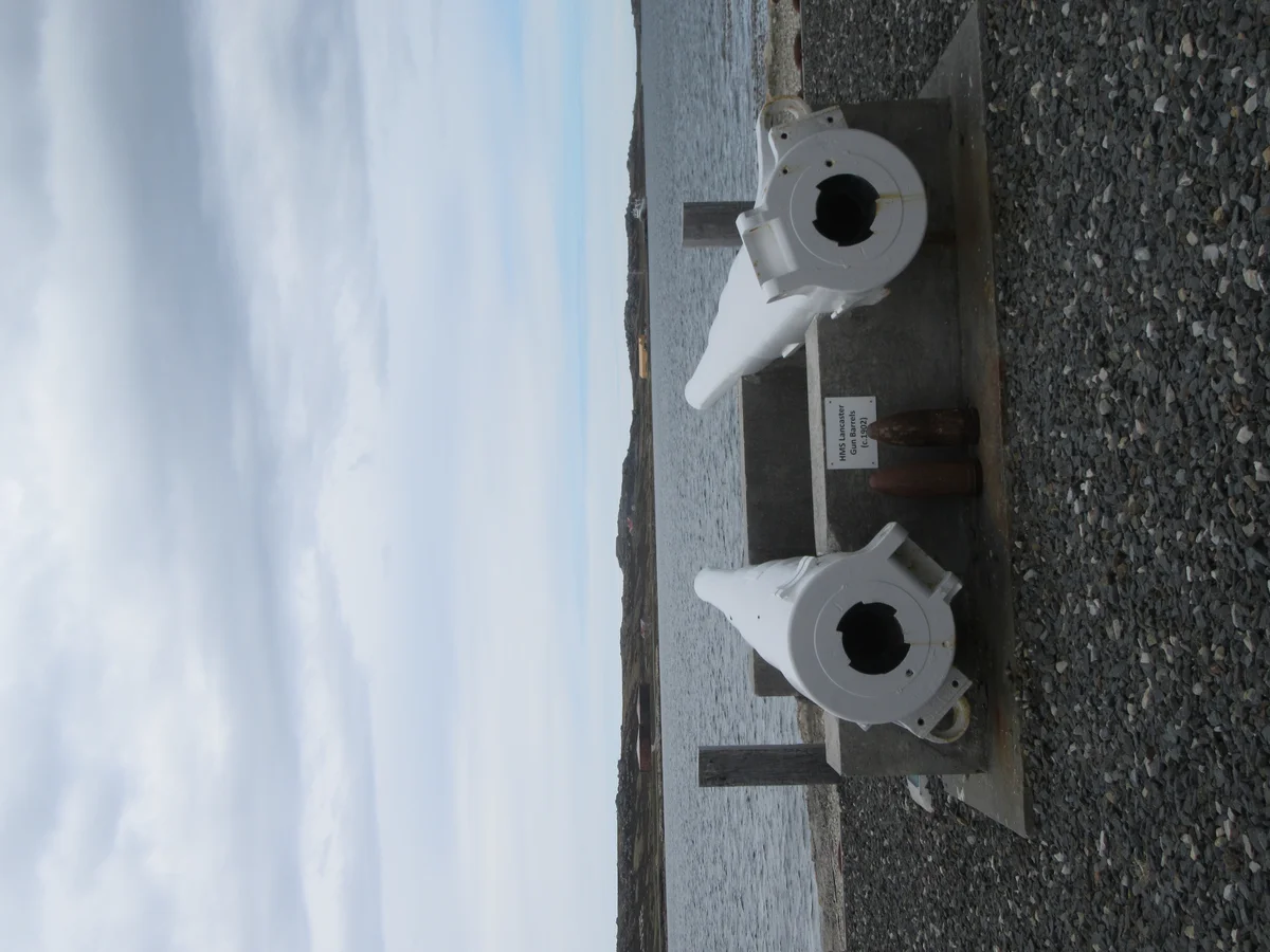 Naval guns at Stanley harborside with memorial significance from wartime era
