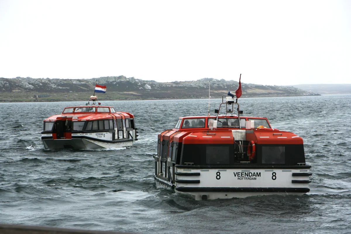 Colorful buildings along Stanley waterfront with hills rising behind the town