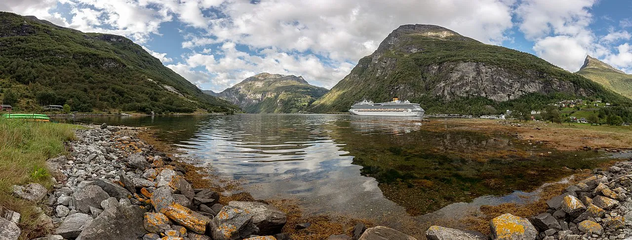 Geirangerfjord UNESCO World Heritage site with emerald waters flanked by towering snow-capped mountains and cascading waterfalls