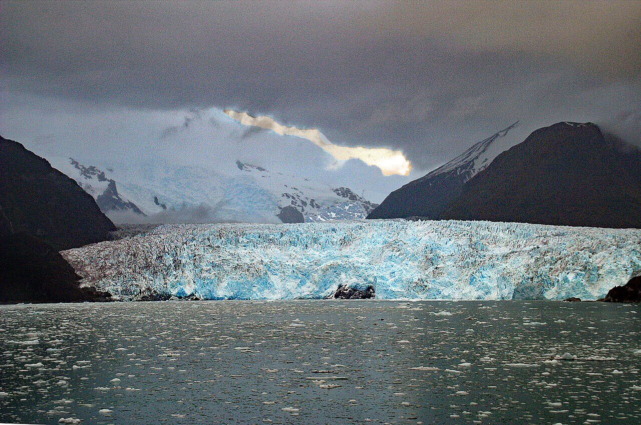 Tidewater glacier flowing into the Beagle Channel with dramatic clouds