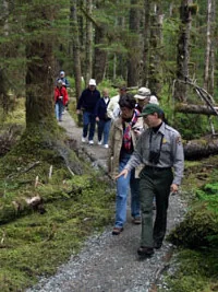 A National Park Service ranger leading a guided forest walk at Bartlett Cove