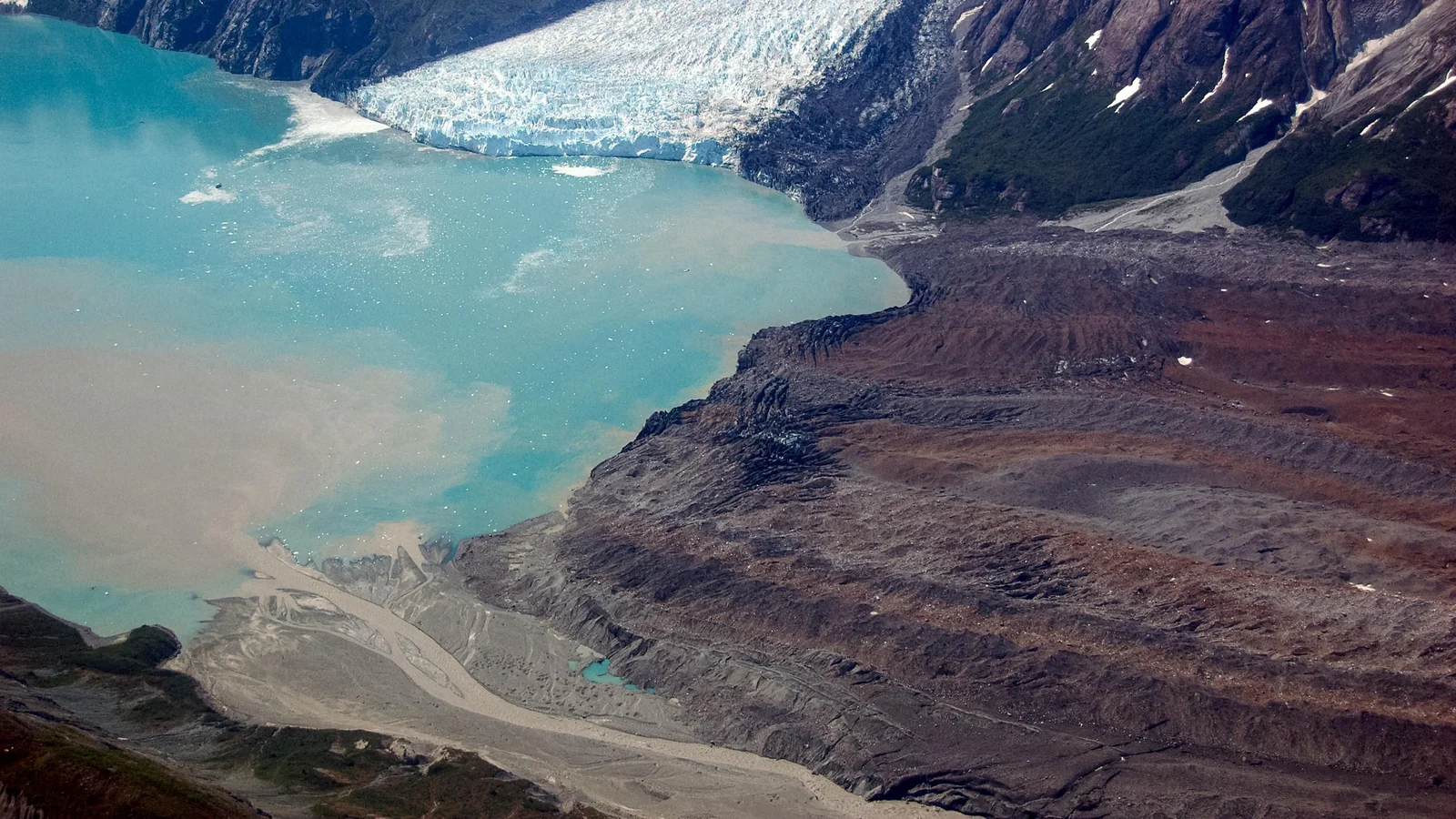 Aerial image of the debris-covered Grand Pacific Glacier reaching Tarr Inlet