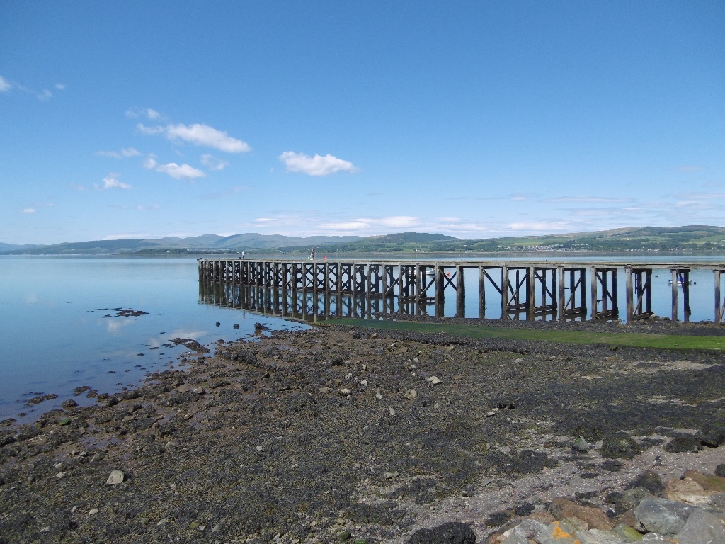 Wooden pier stretching into the Firth of Clyde with Scottish hills