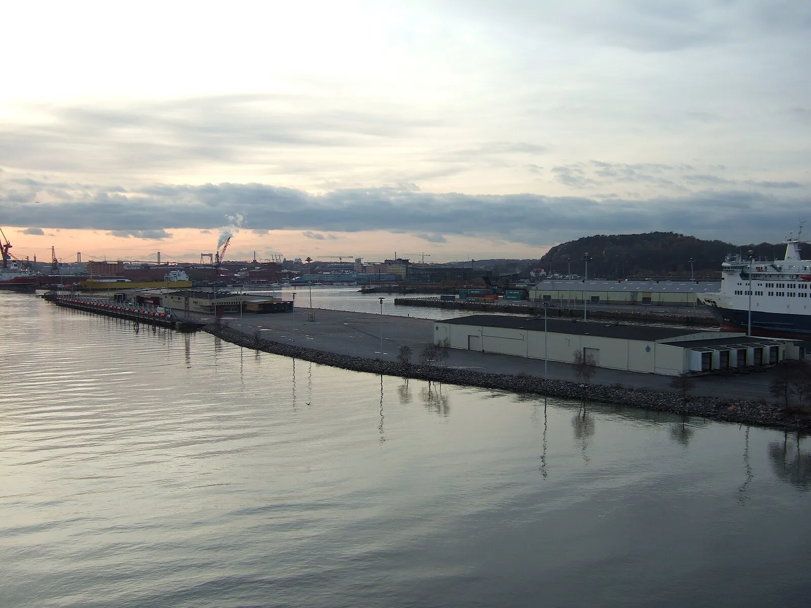 Gothenburg harbor at dusk with industrial cranes and ferry