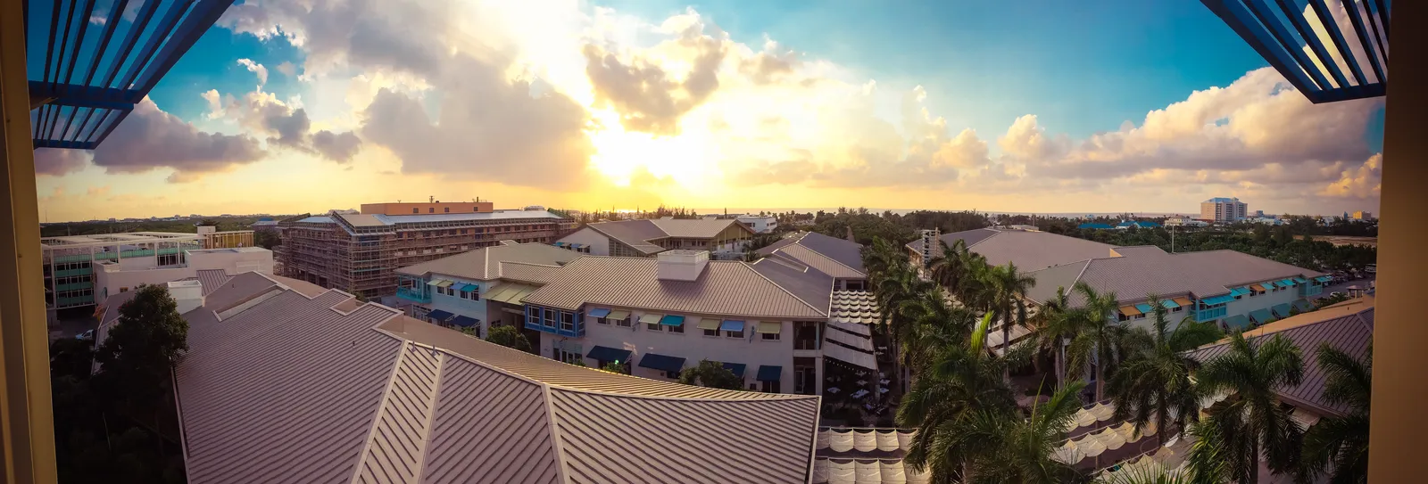Seven Mile Beach panoramic view with crystal clear turquoise Caribbean water stretching along white sand coastline under blue Cayman Islands skies