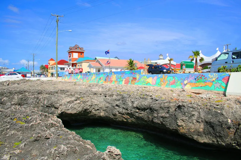 George Town waterfront with colorful colonial buildings and cruise tender dock under Caribbean sunshine