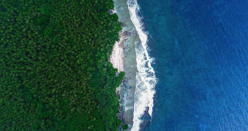 Tropical coastline view of Tumon Bay in Guam with turquoise waters and lush green hills