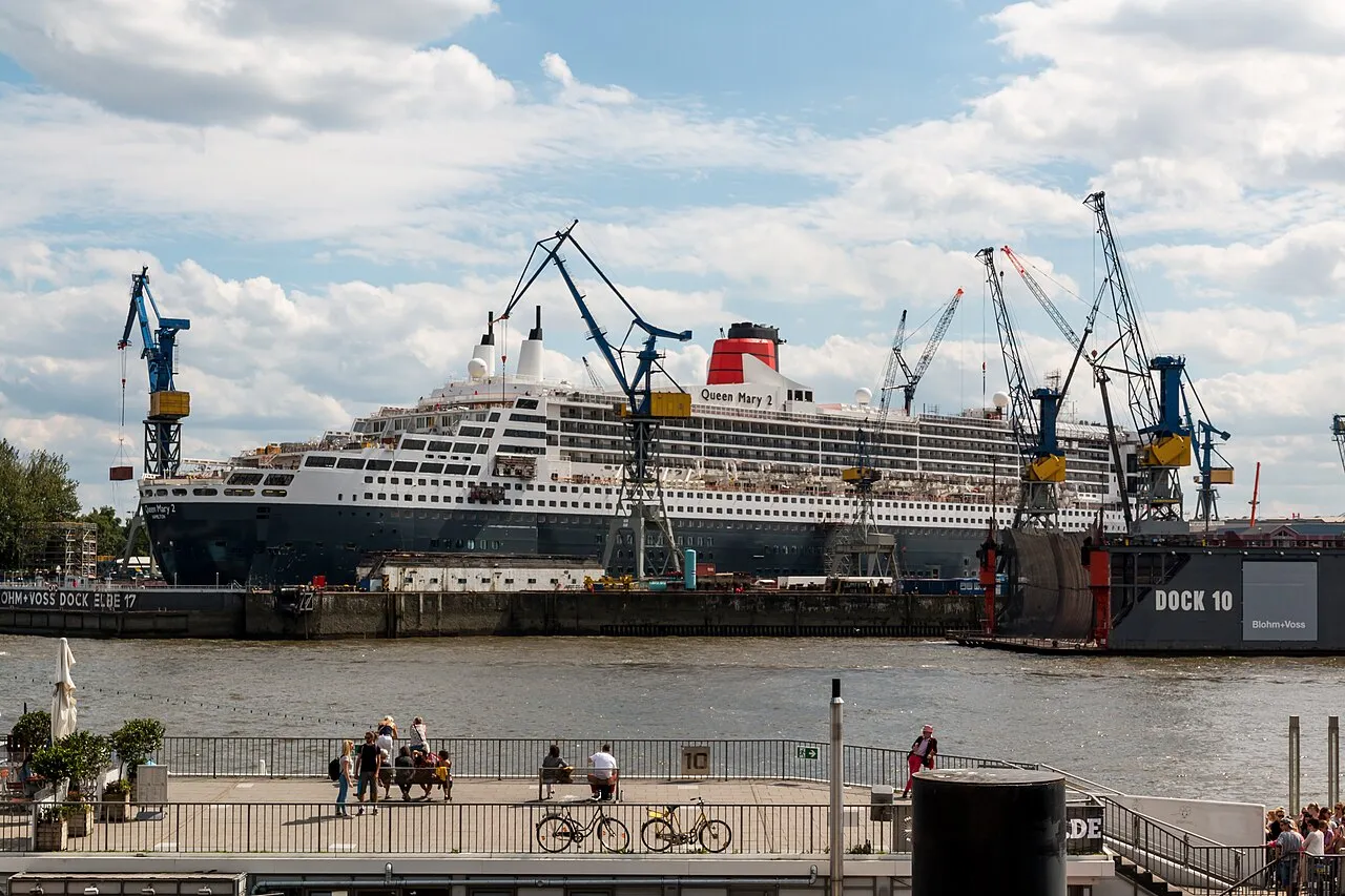 Queen Mary 2 at Blohm+Voss with Dock 10 sign and Elbe promenade