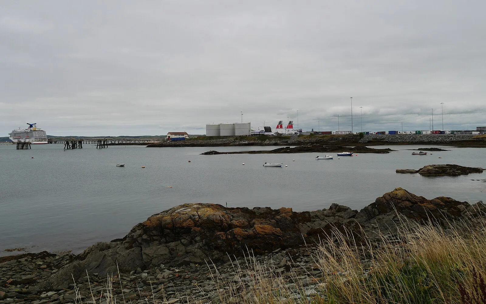 Carnival cruise ship docked at Holyhead pier with Stena Line ferries and rocky foreground