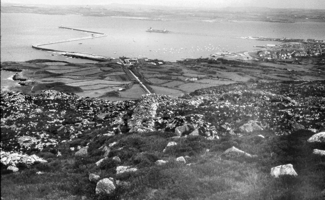 Historical black and white photograph of Holyhead harbour from Holyhead Mountain showing breakwater and port