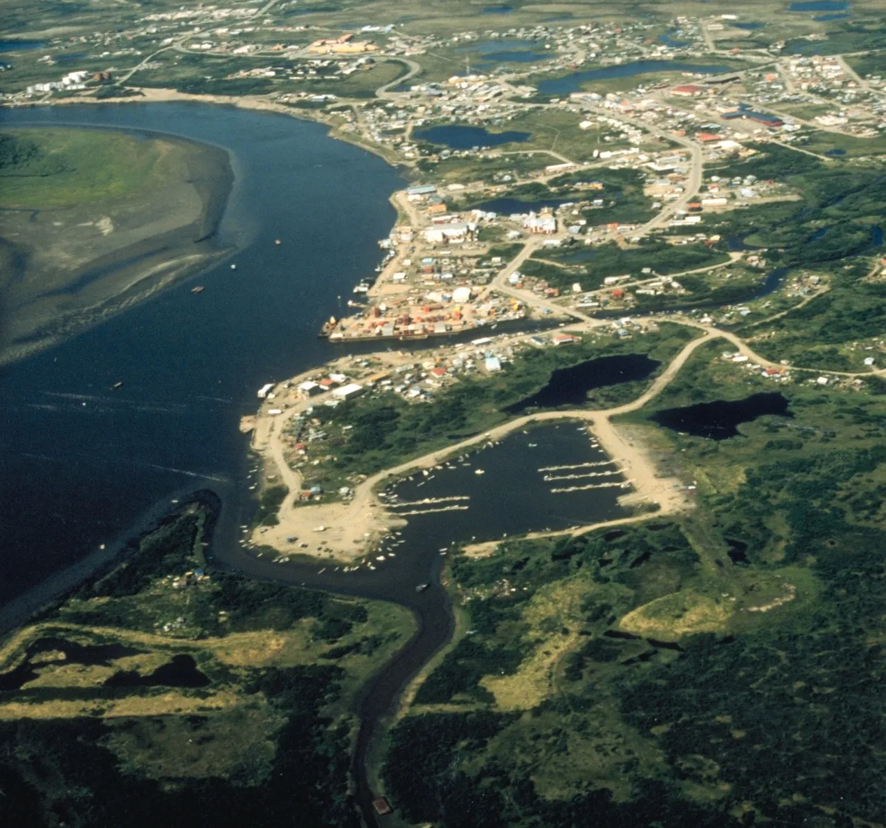 Aerial view of the Homer Spit extending 4.5 miles into Kachemak Bay with fishing boats lining the harbor