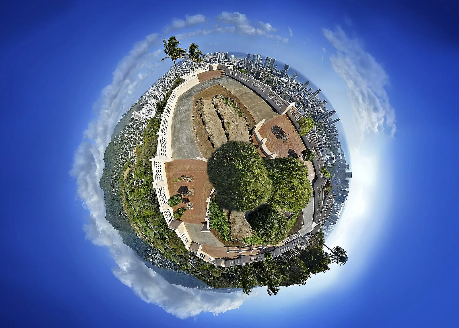 Little planet 360-degree panorama of a Honolulu park with the city skyline wrapped around the sphere