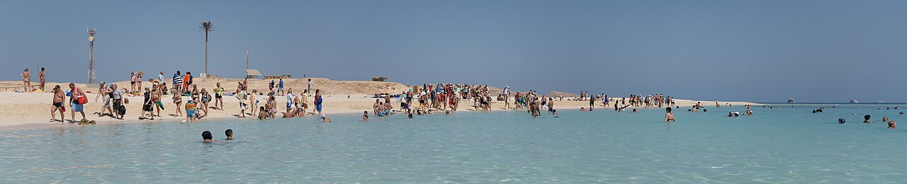 Panoramic view of Hurghada's coastline with turquoise waters, resort buildings, and desert mountains in the distance